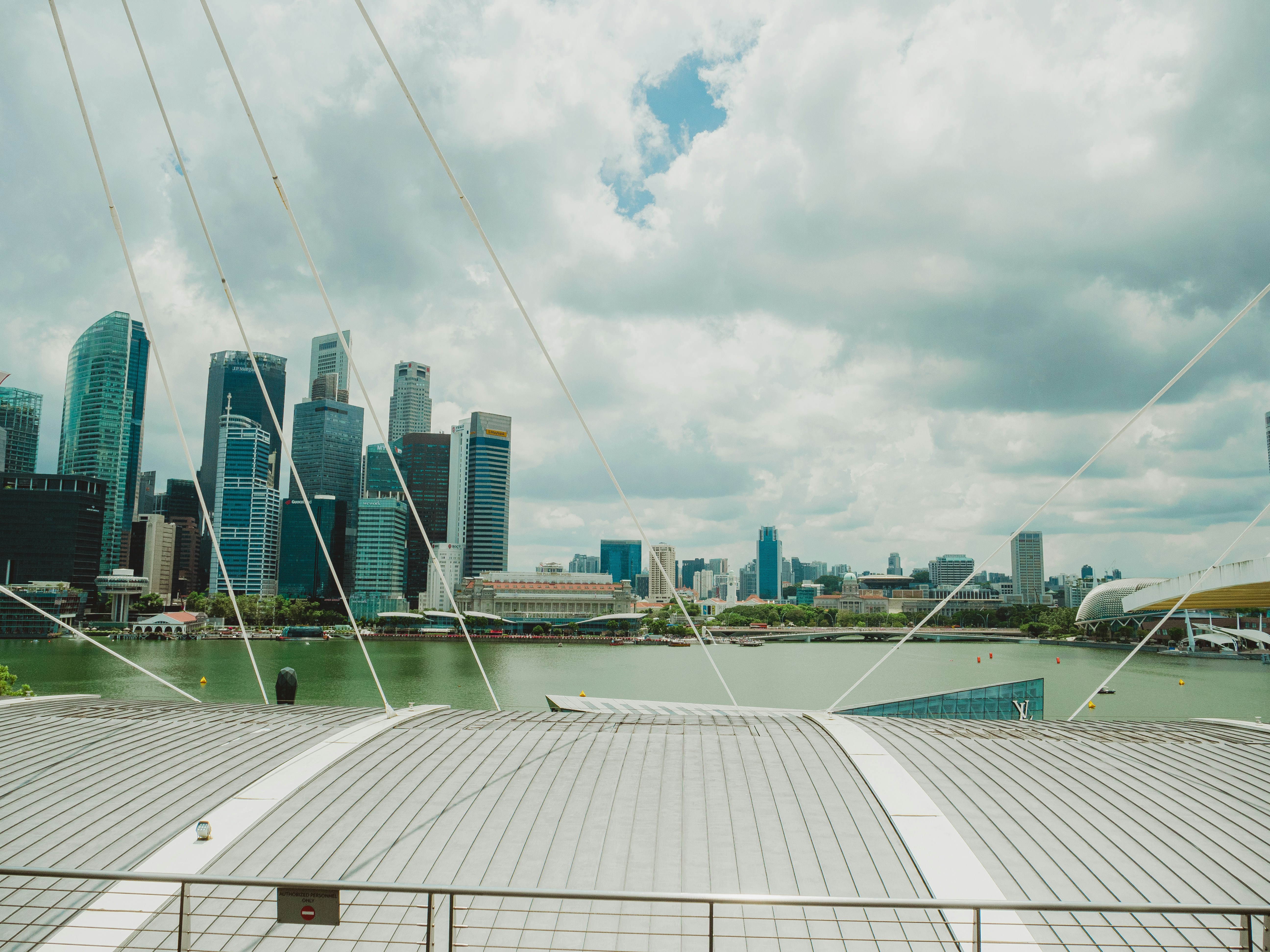 Singapore skyline with cloudy skies and water.