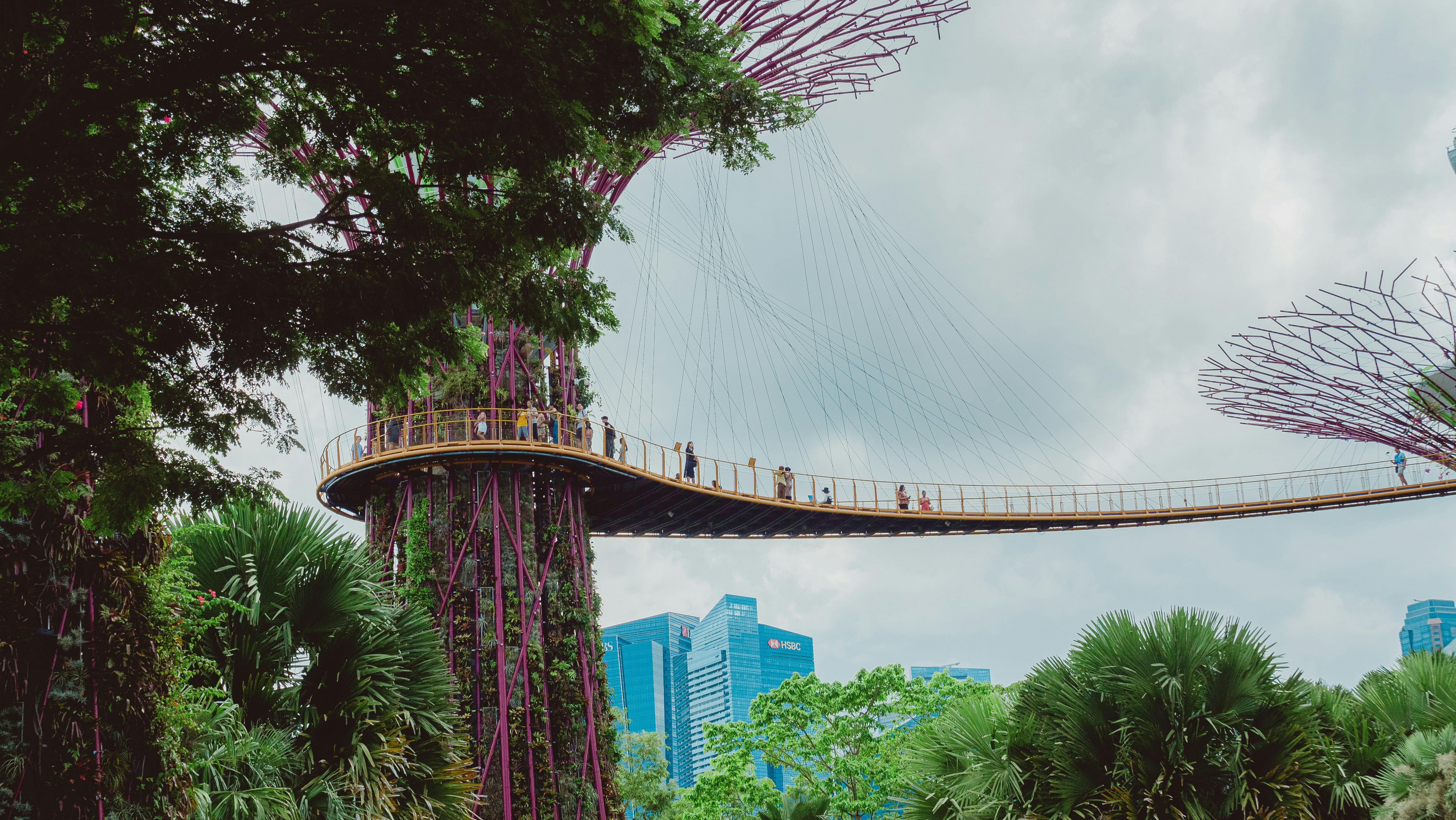 Un pont relie des tours dans un jardin.