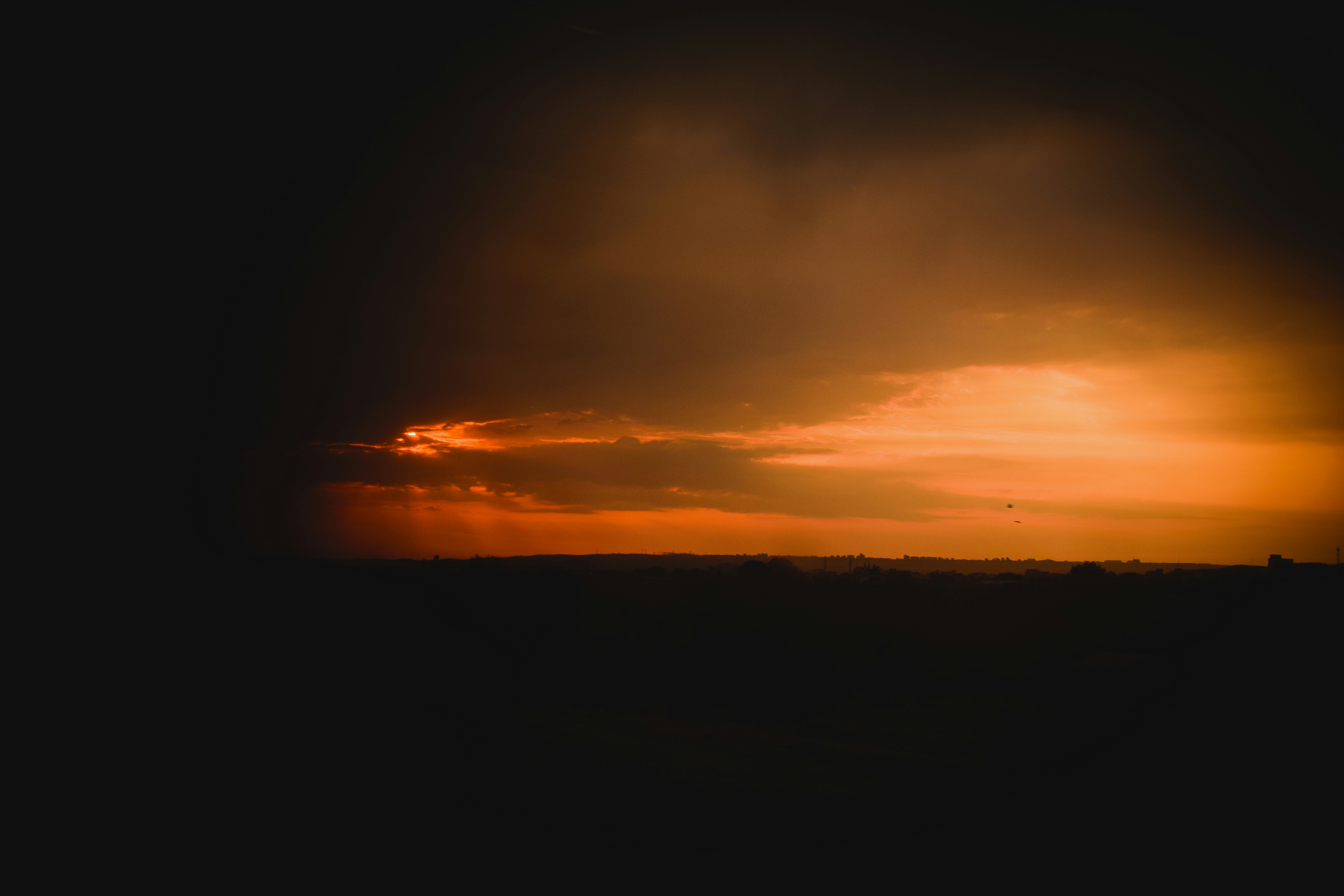 Dunkle Wolken umgeben einen wunderschönen, feurigen Sonnenuntergang ...