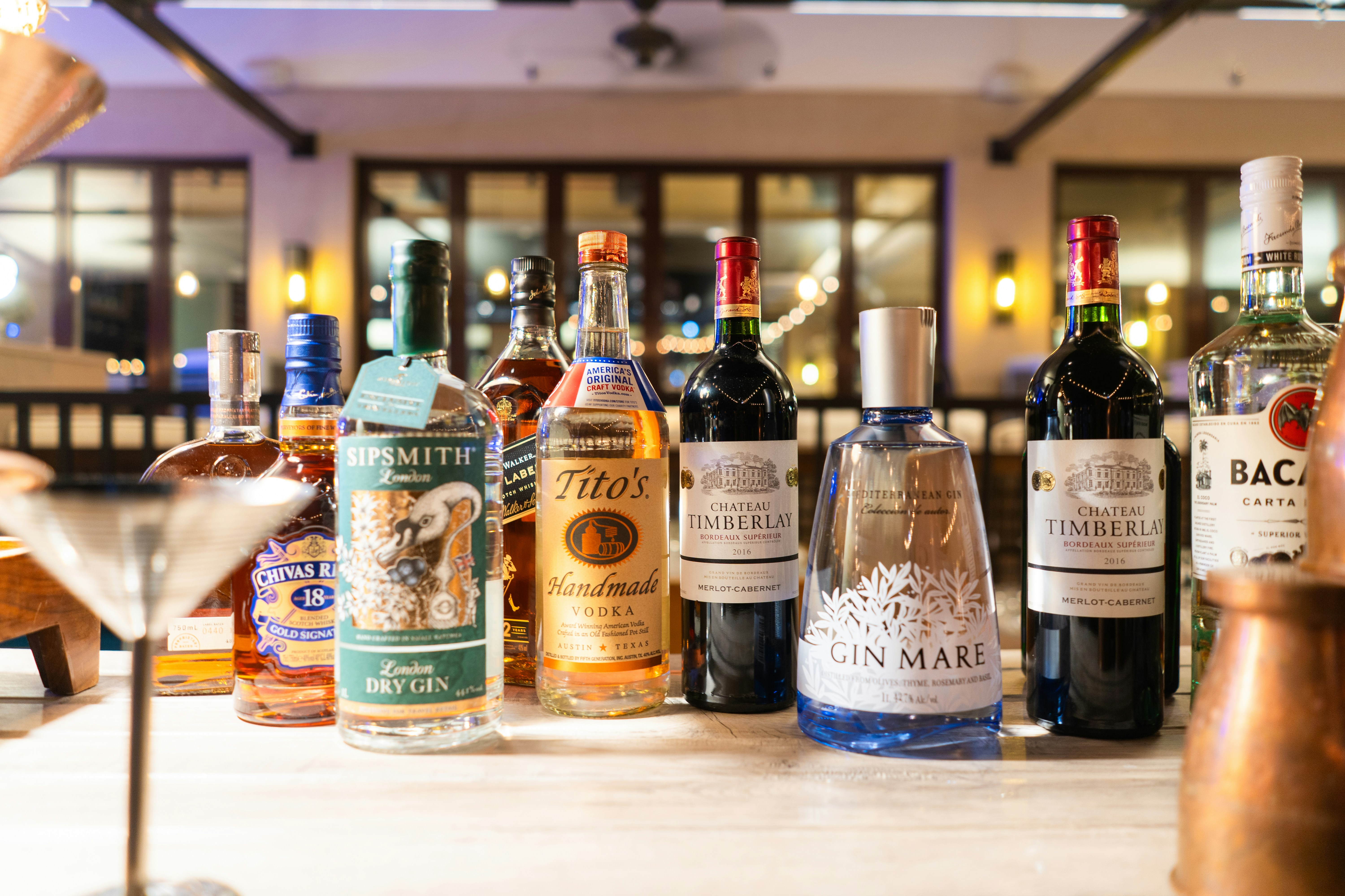 Several bottles of liquor sit on a bar.