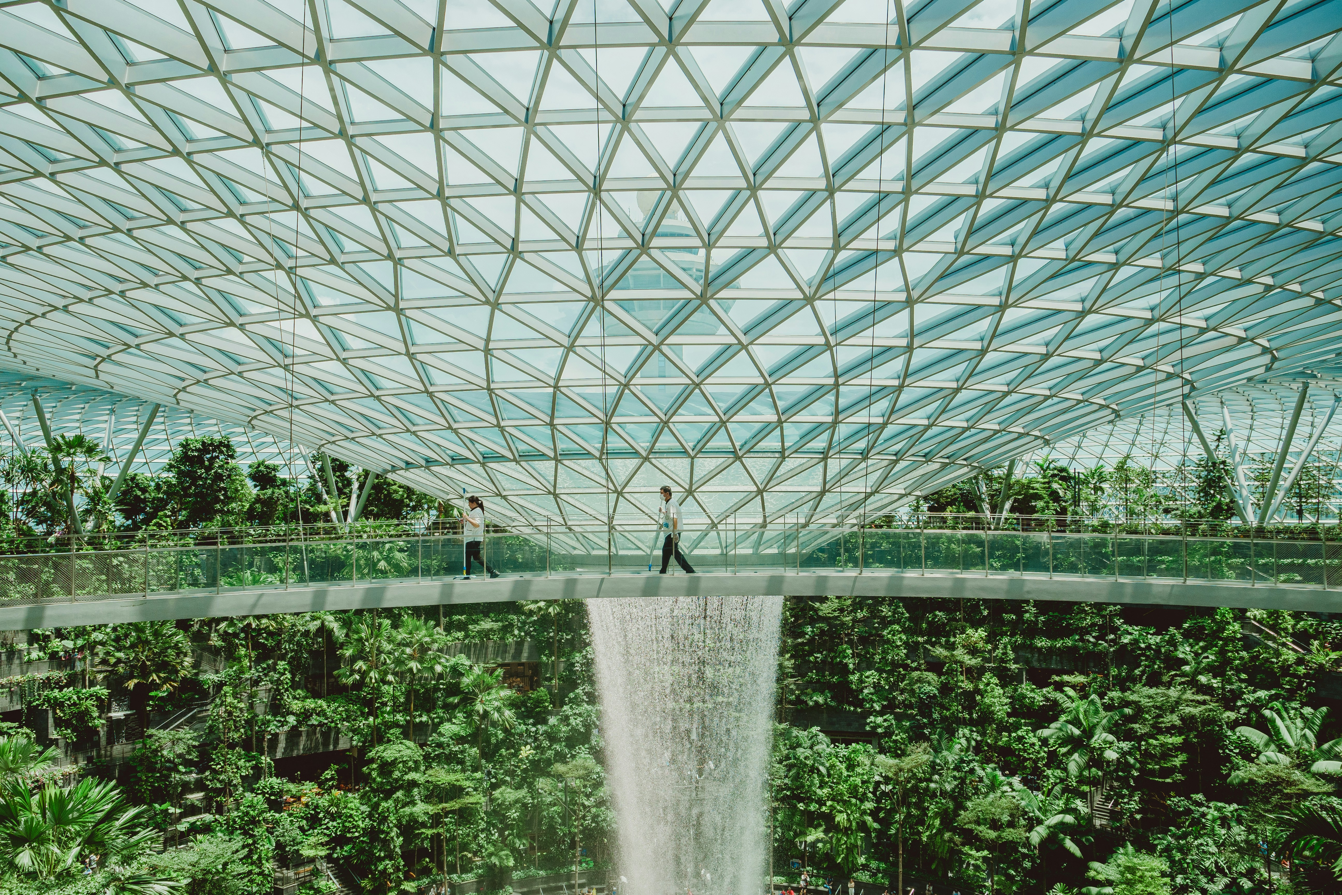 People are viewing a waterfall inside of a building.