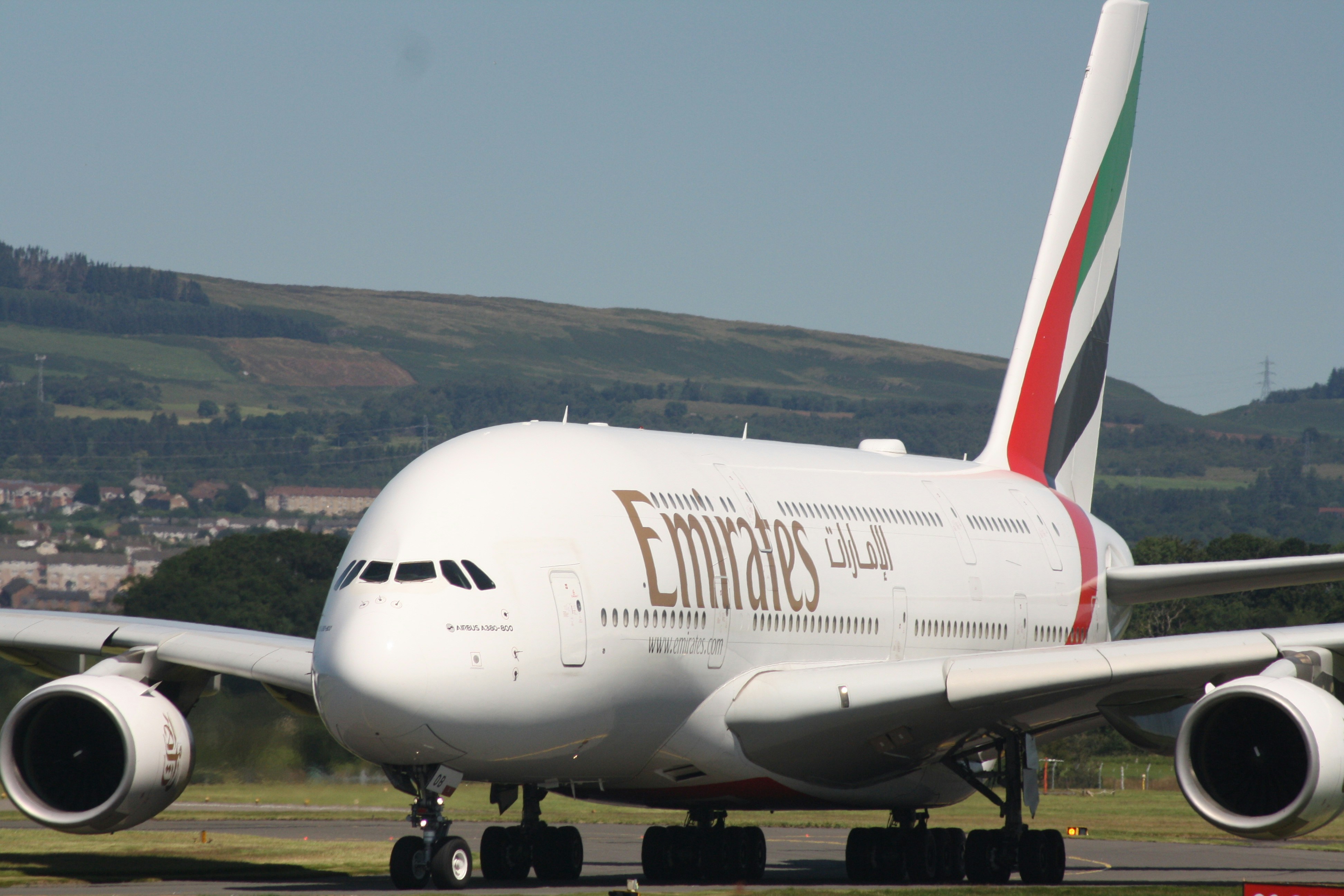 An emirates airplane is on the ground