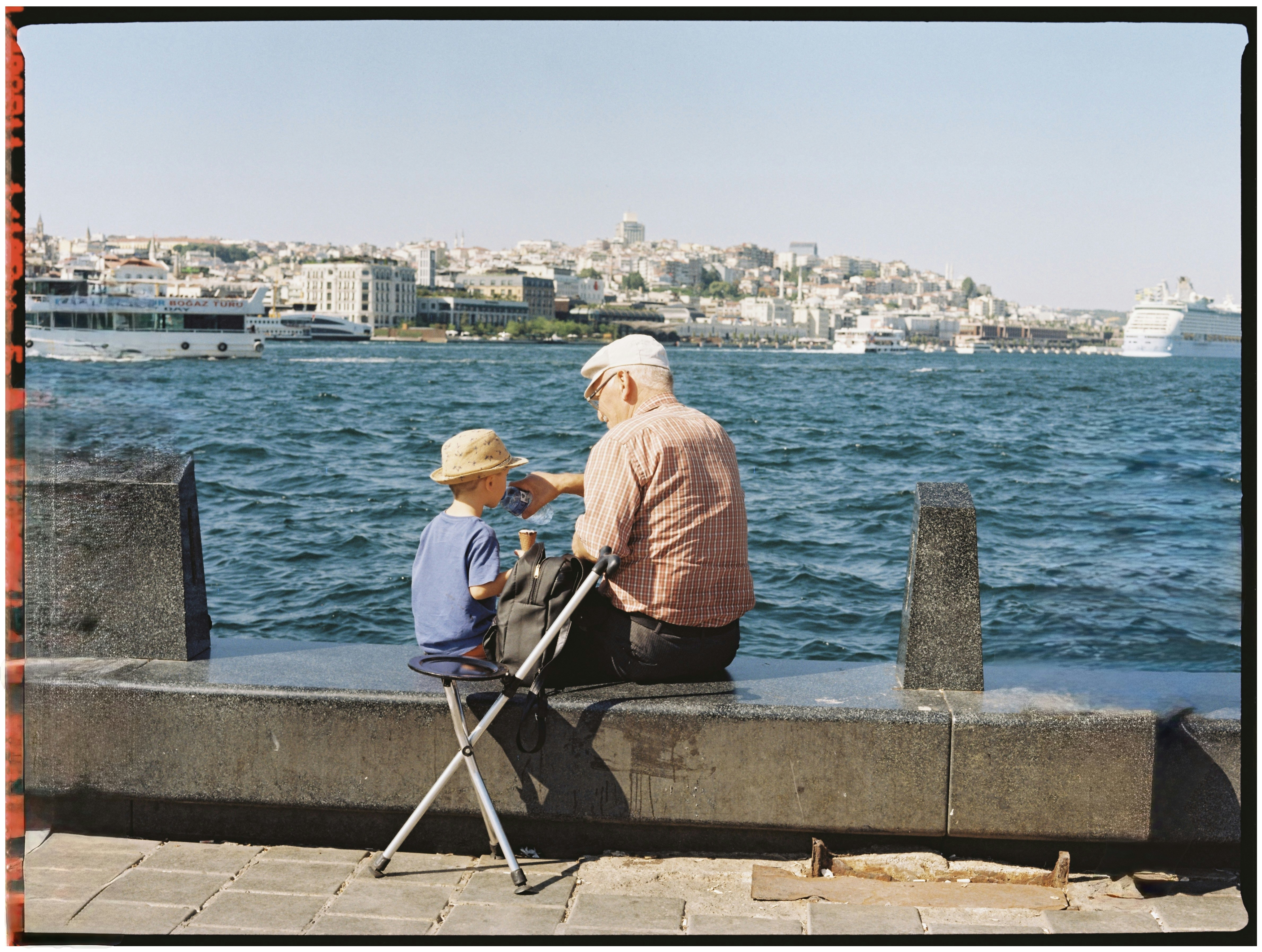 Grandfather and grandson share a moment by the sea.