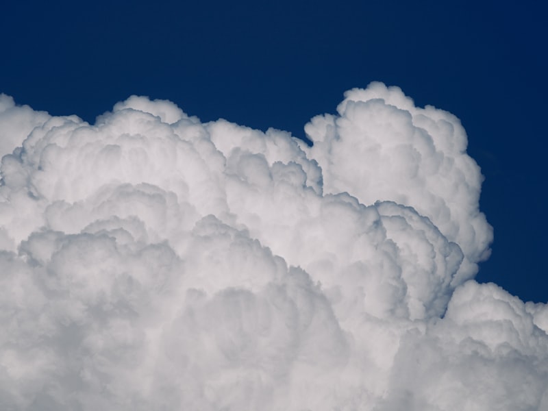 Fluffy white clouds against a dark blue sky