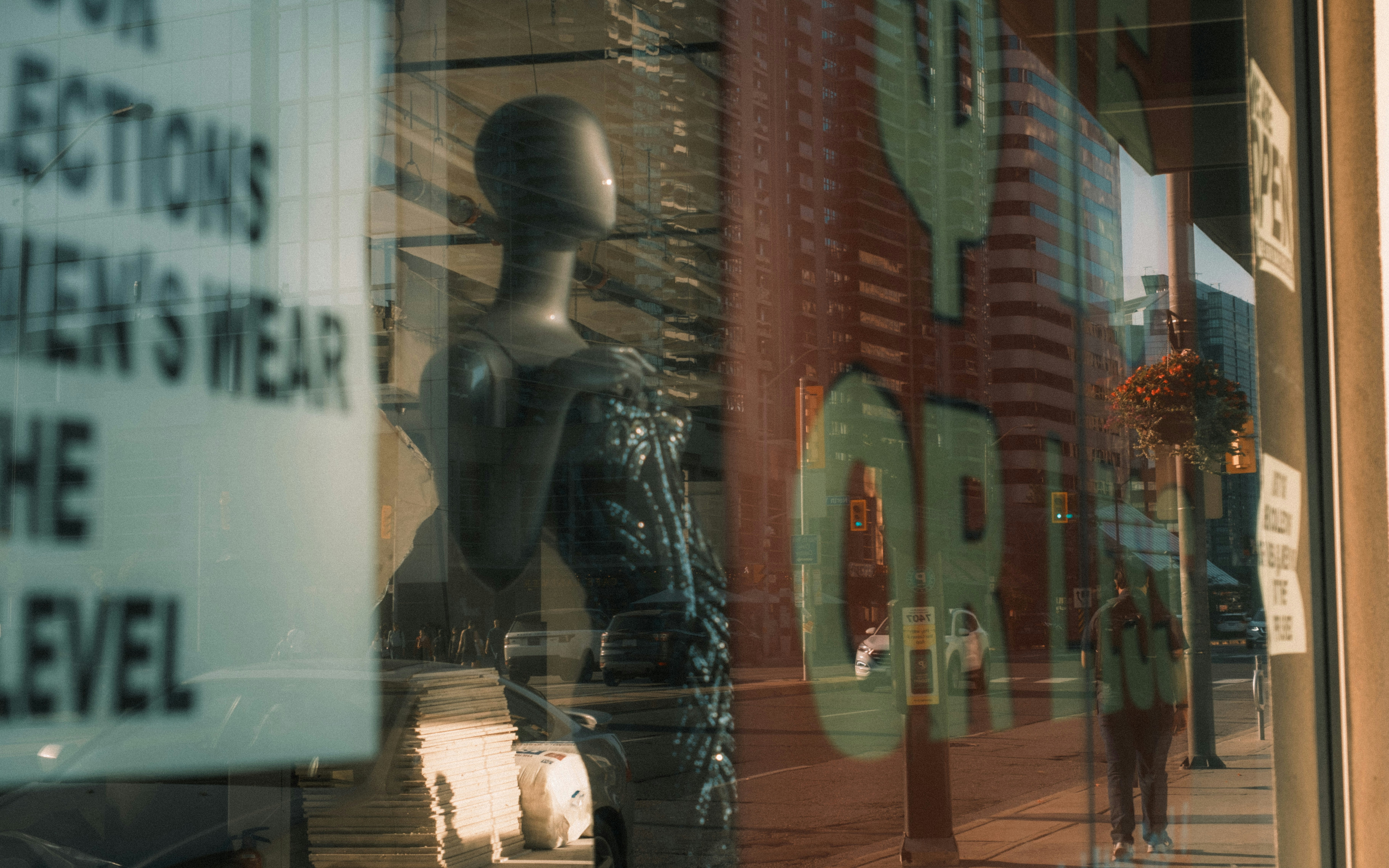 Mannequin and reflections in a storefront window.