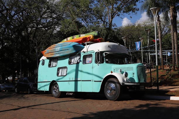 A campervan with kayaks parked on a sunny day.
