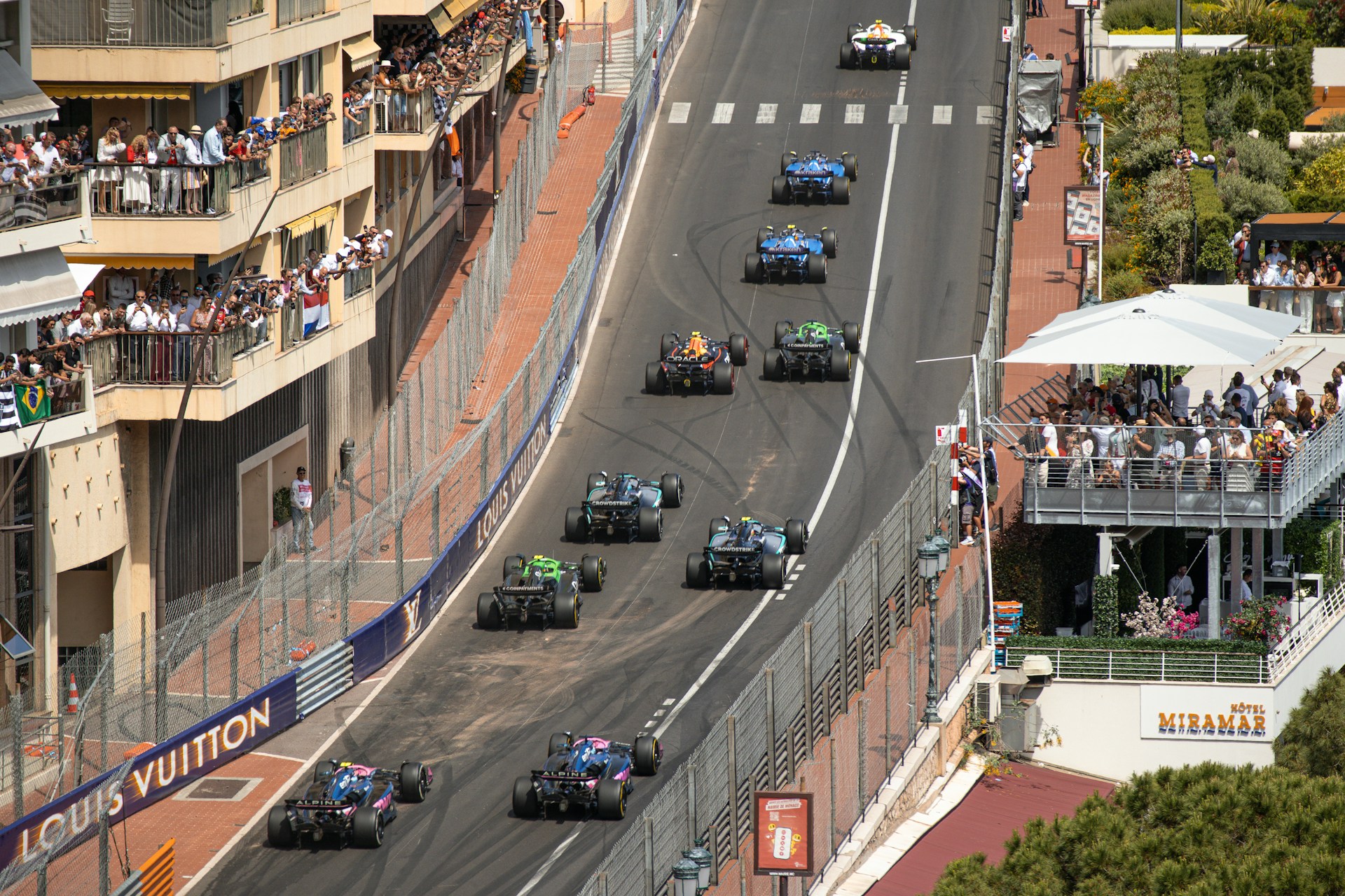 Formula one race cars navigate a tight track.