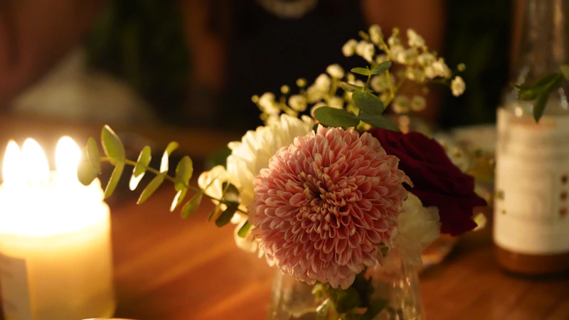 A candle and flowers decorate a table.