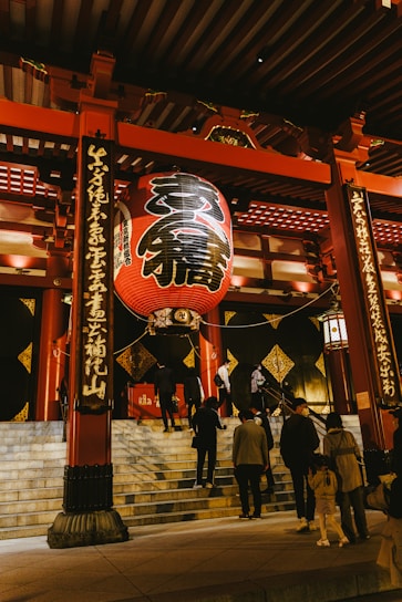 People walk toward a traditional japanese temple.