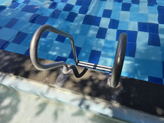Pool ladder leads into clear blue water.