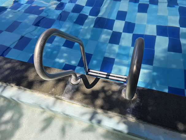 Pool ladder leads into clear blue water.