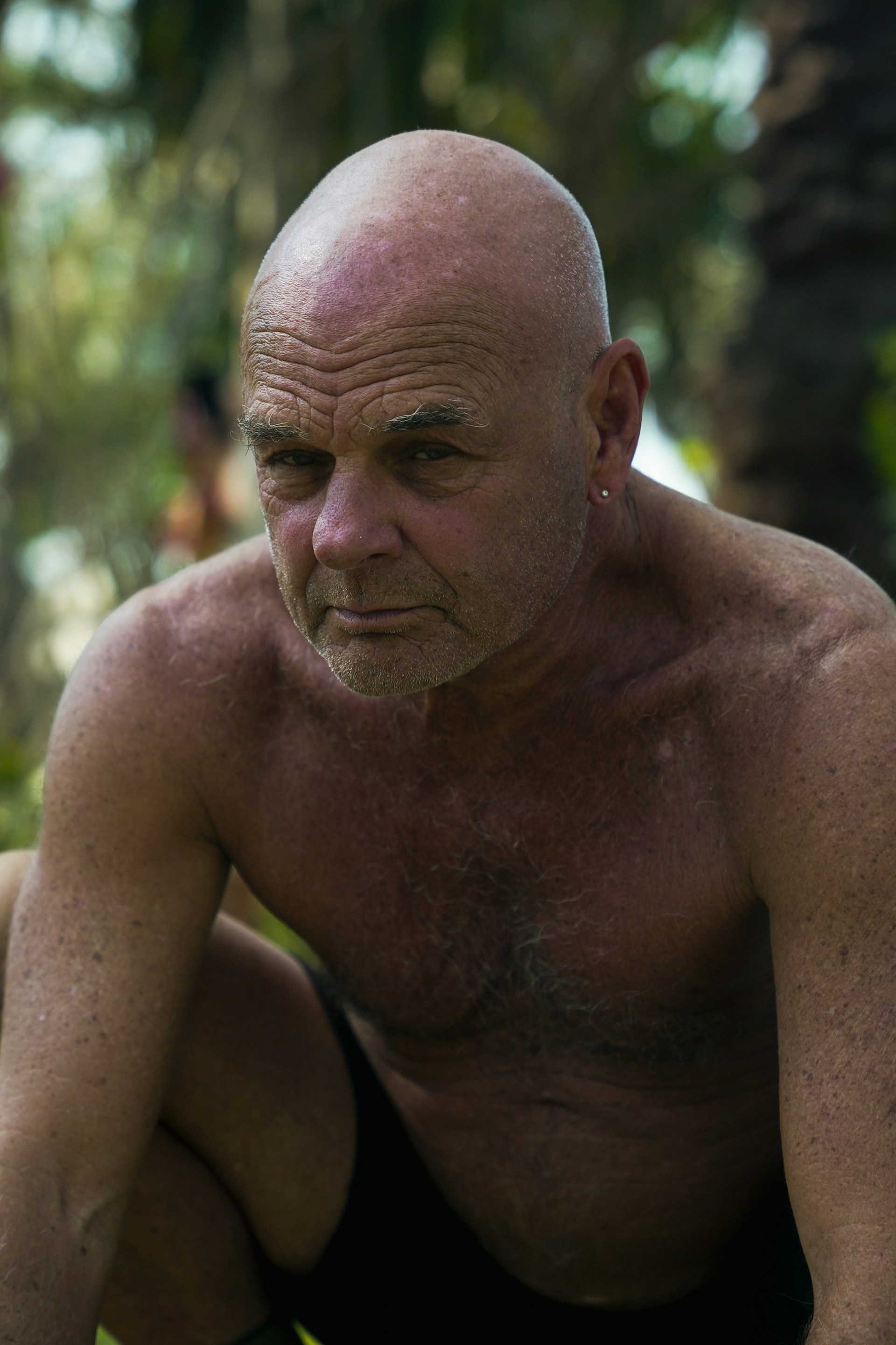 A bald man looks intensely into the camera.