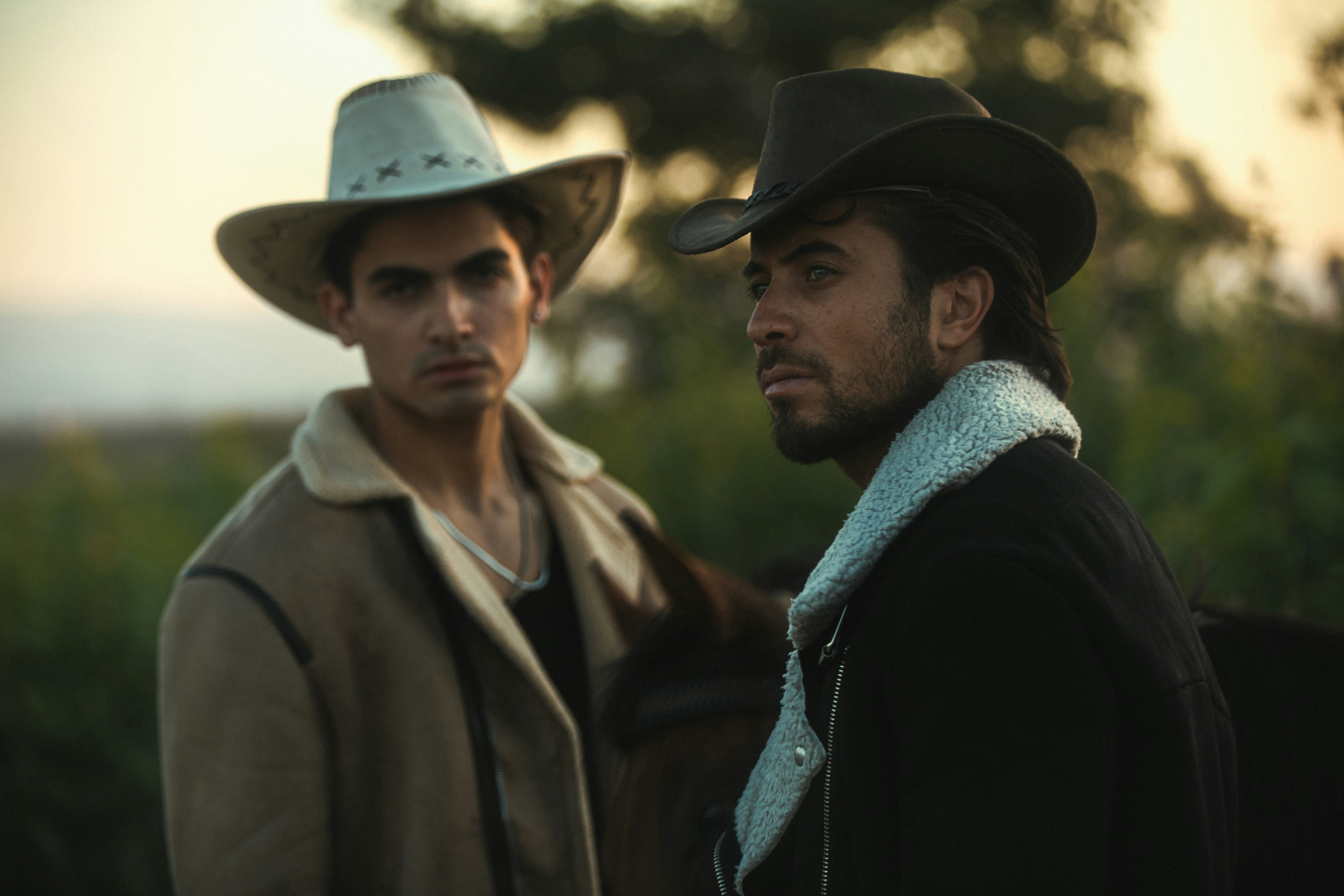 Two cowboys looking intently at something off-camera.