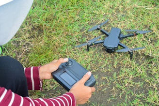 Person holding drone remote control near drone