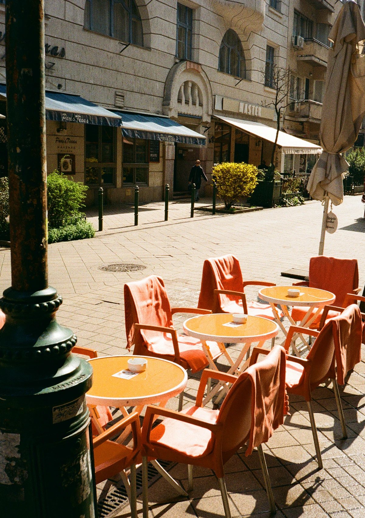 Outdoor café seating along a sunny street, representing walkable shops, cafés, and dining near Parkway Motel Queanbeyan