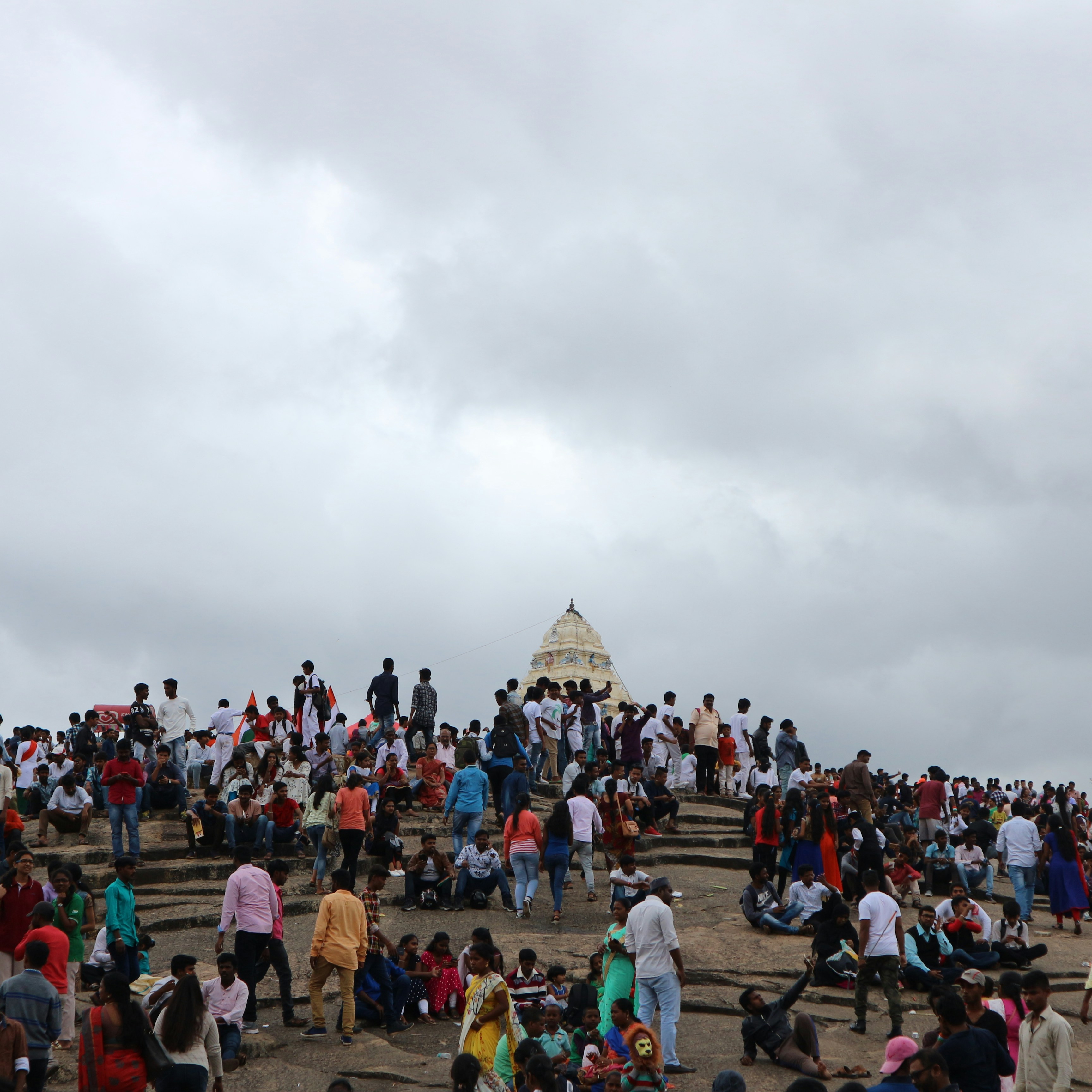 Menschen versammeln sich an einem bewölkten Tag in der Nähe eines Tempels.
