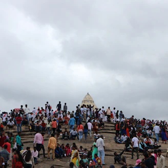 People gather near a temple on a cloudy day.