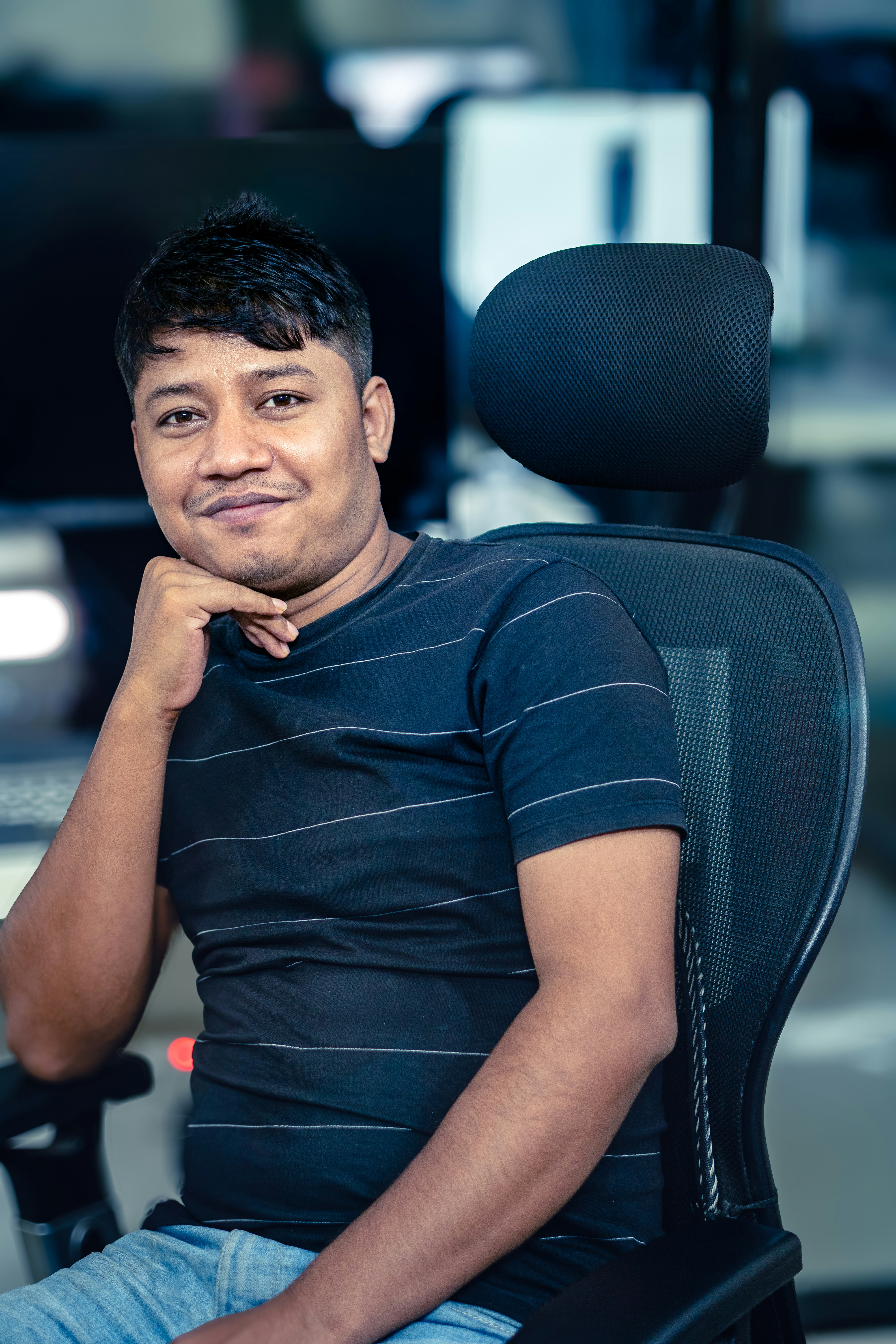 A man poses for a photo in his office chair.