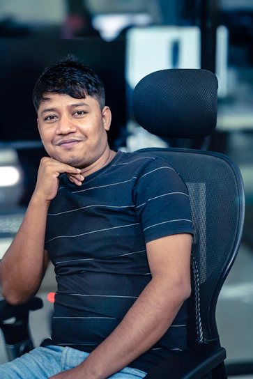A man poses for a photo in his office chair.