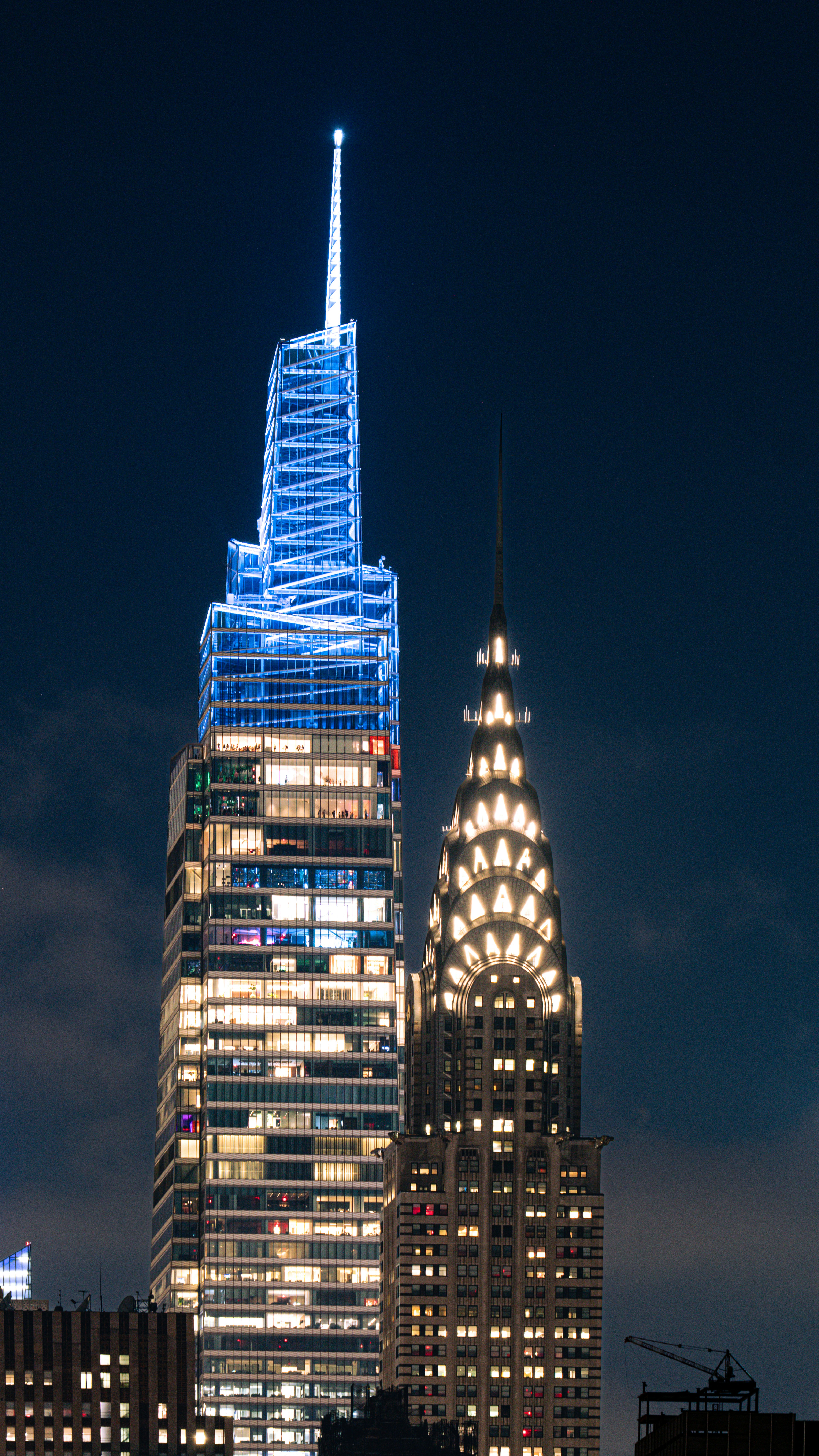 Two skyscrapers light up the night sky.