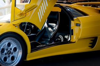 Yellow lamborghini with its doors open.