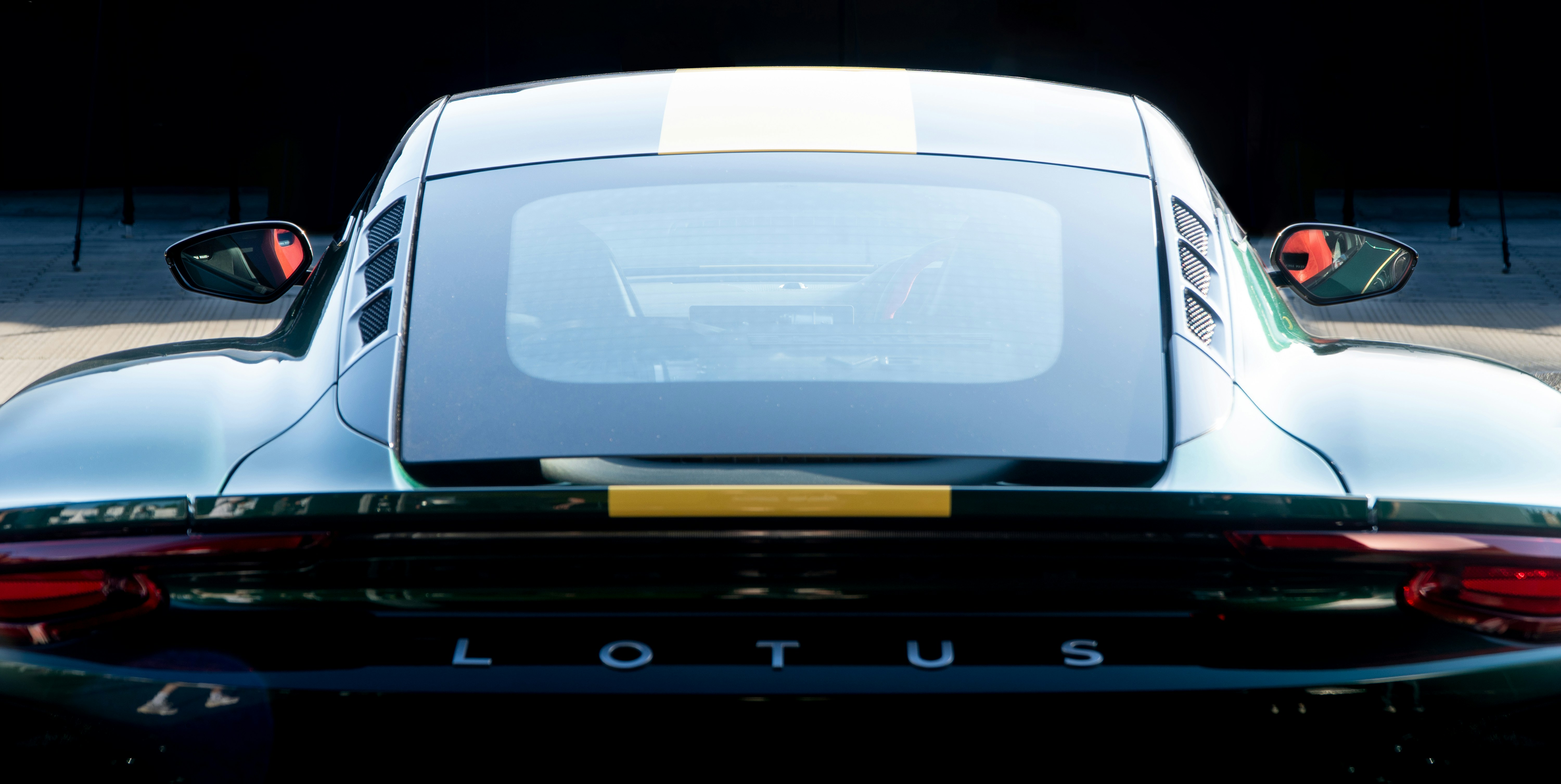 A luxury car being prepared for transport, with a focus on detailing and documentation