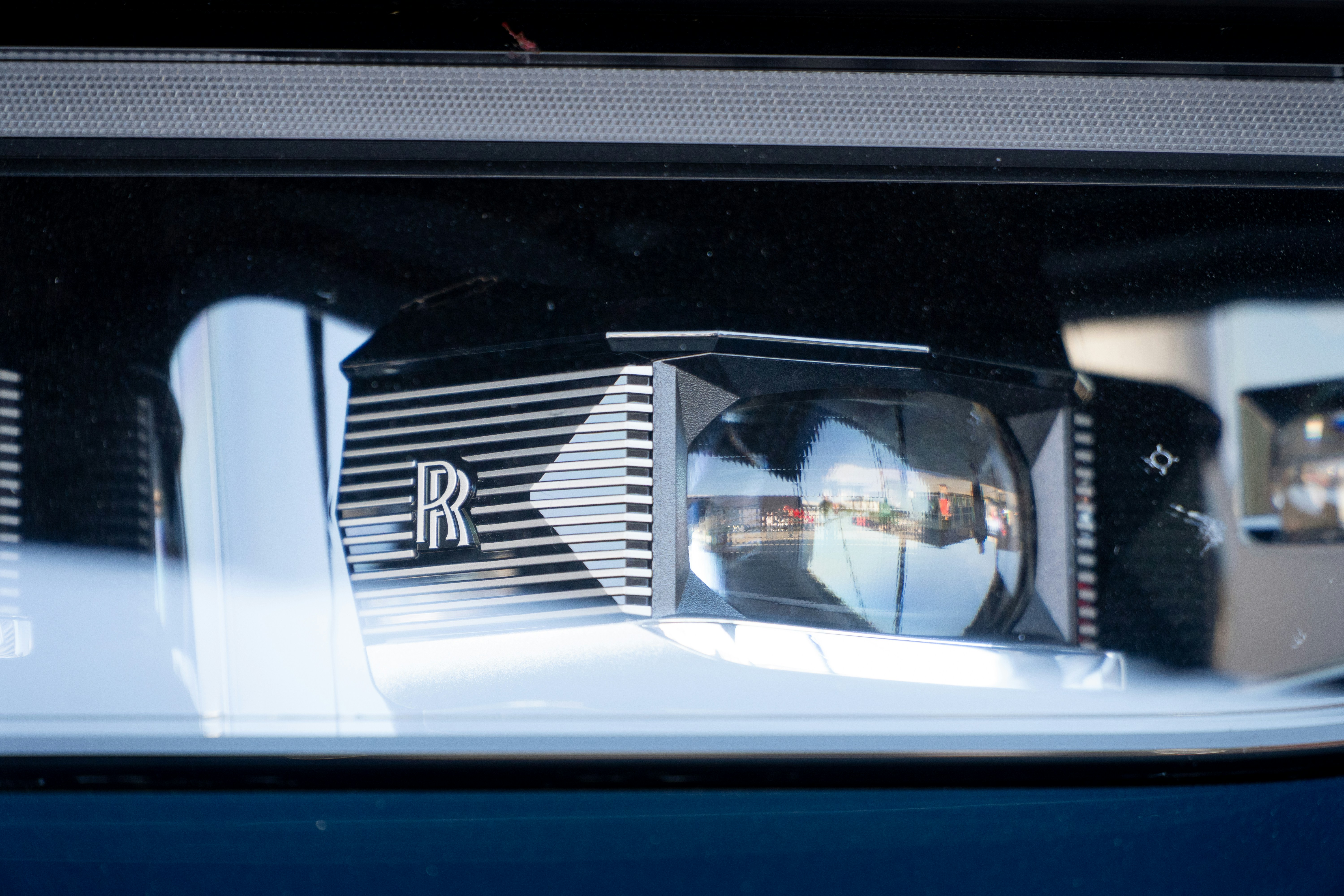 A close-up of a rolls-royce headlight.