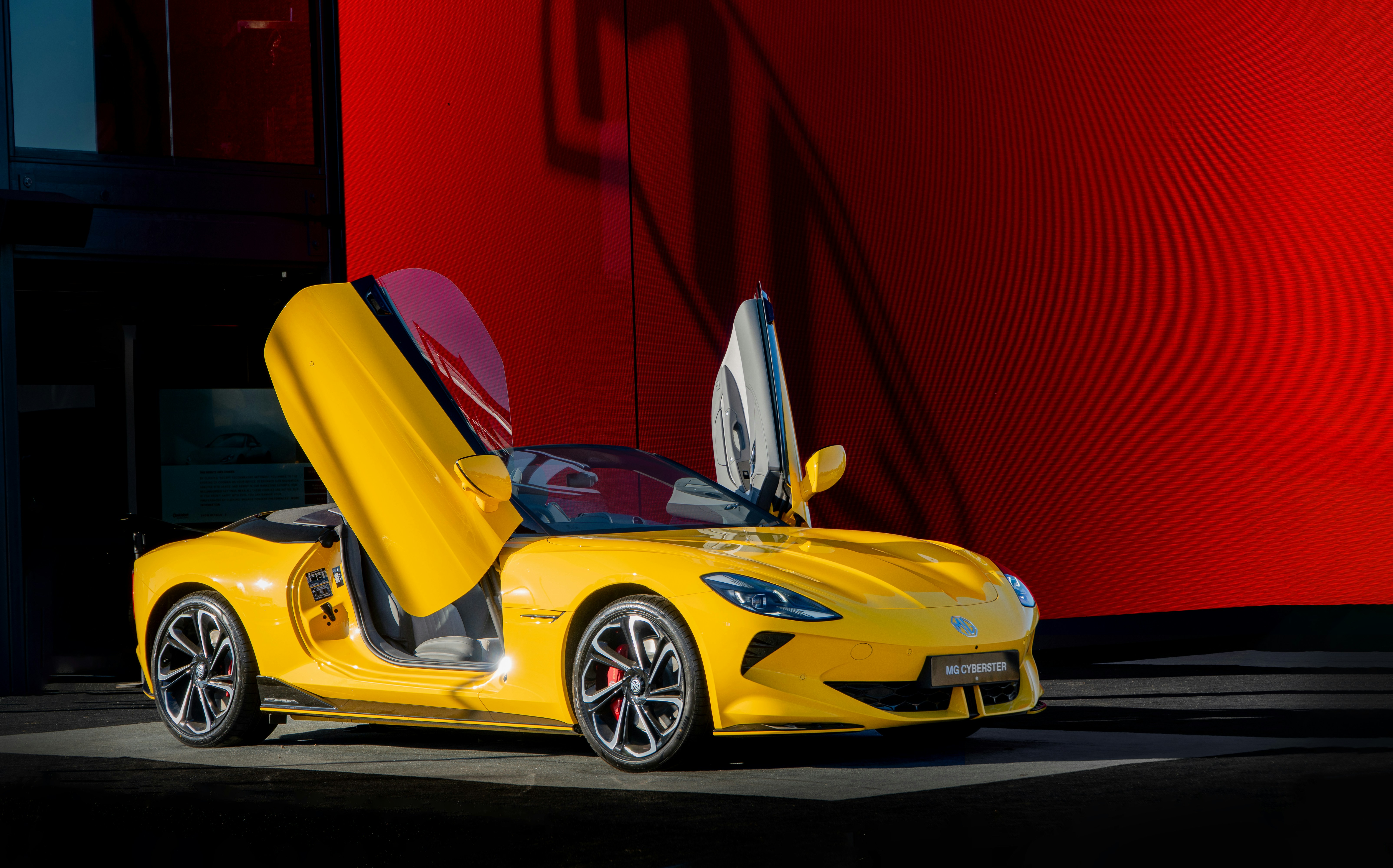 A yellow sports car has its doors open.