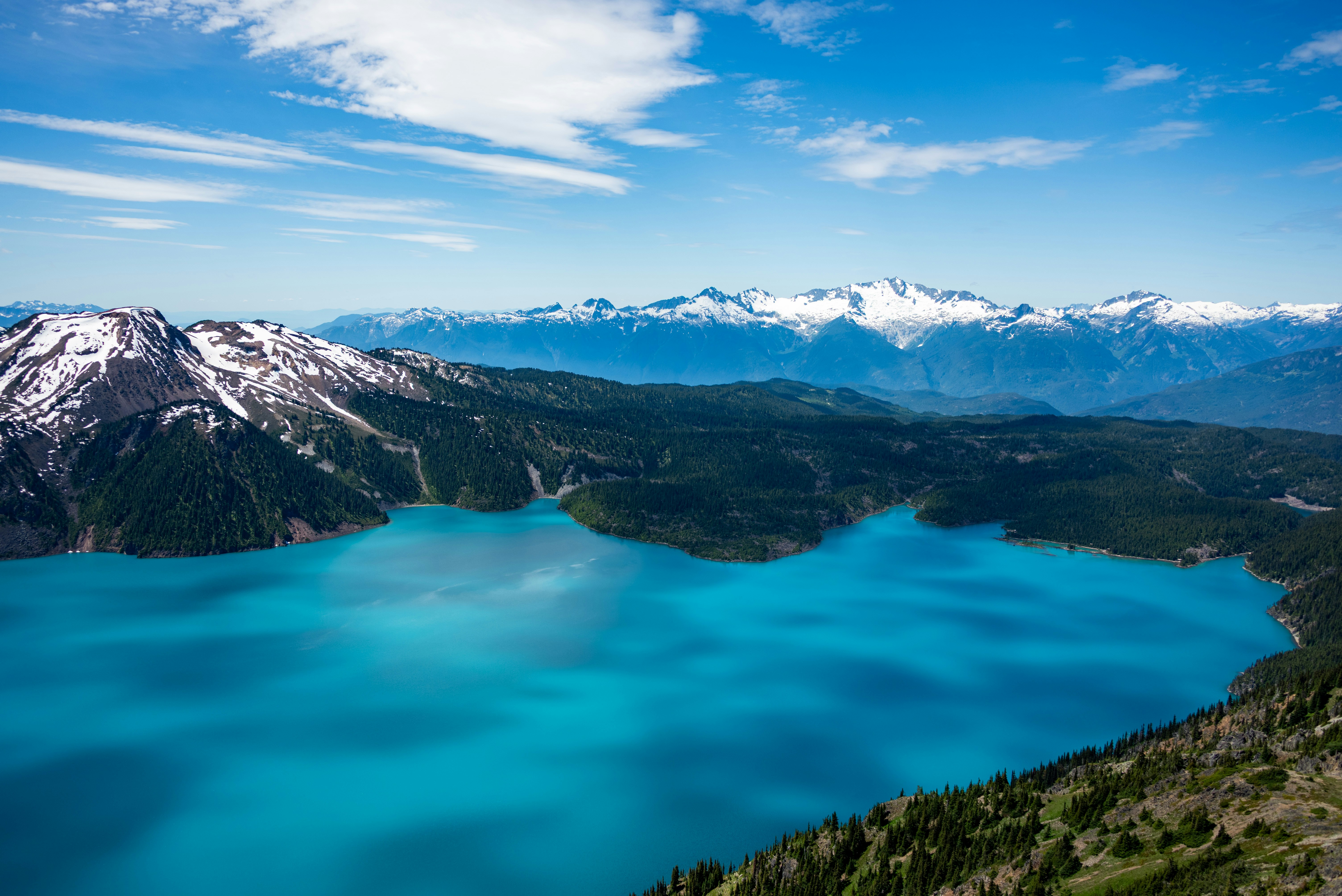 Lac turquoise niché sous des montagnes enneigées.