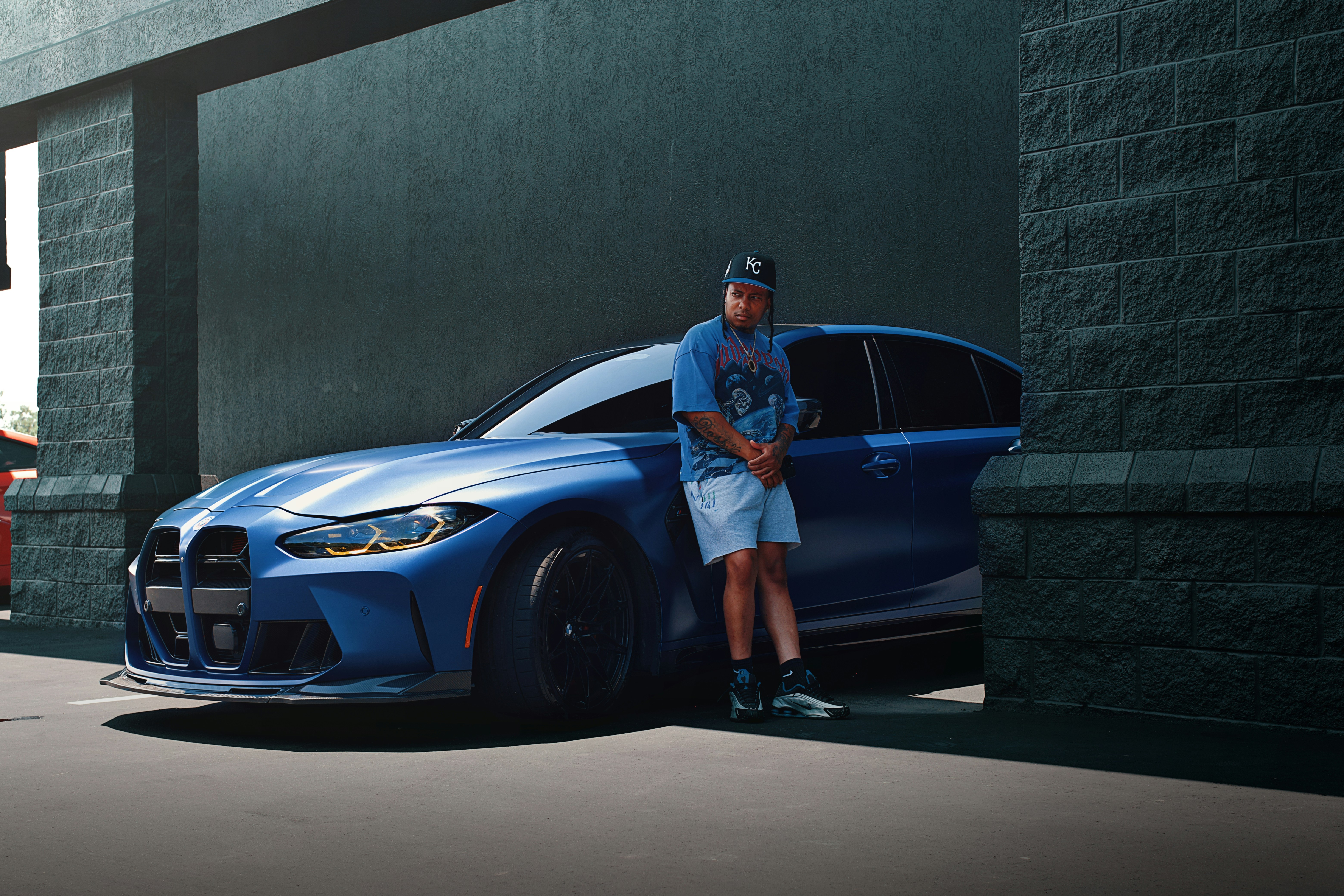 L'uomo si trova accanto alla sua elegante bmw blu.