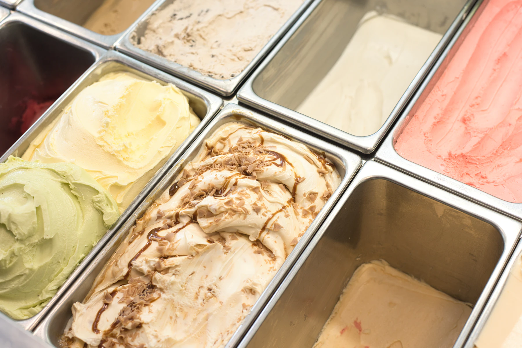 Gelato in steel display pans: pistachio, vanilla, a caramel swirl and strawberry