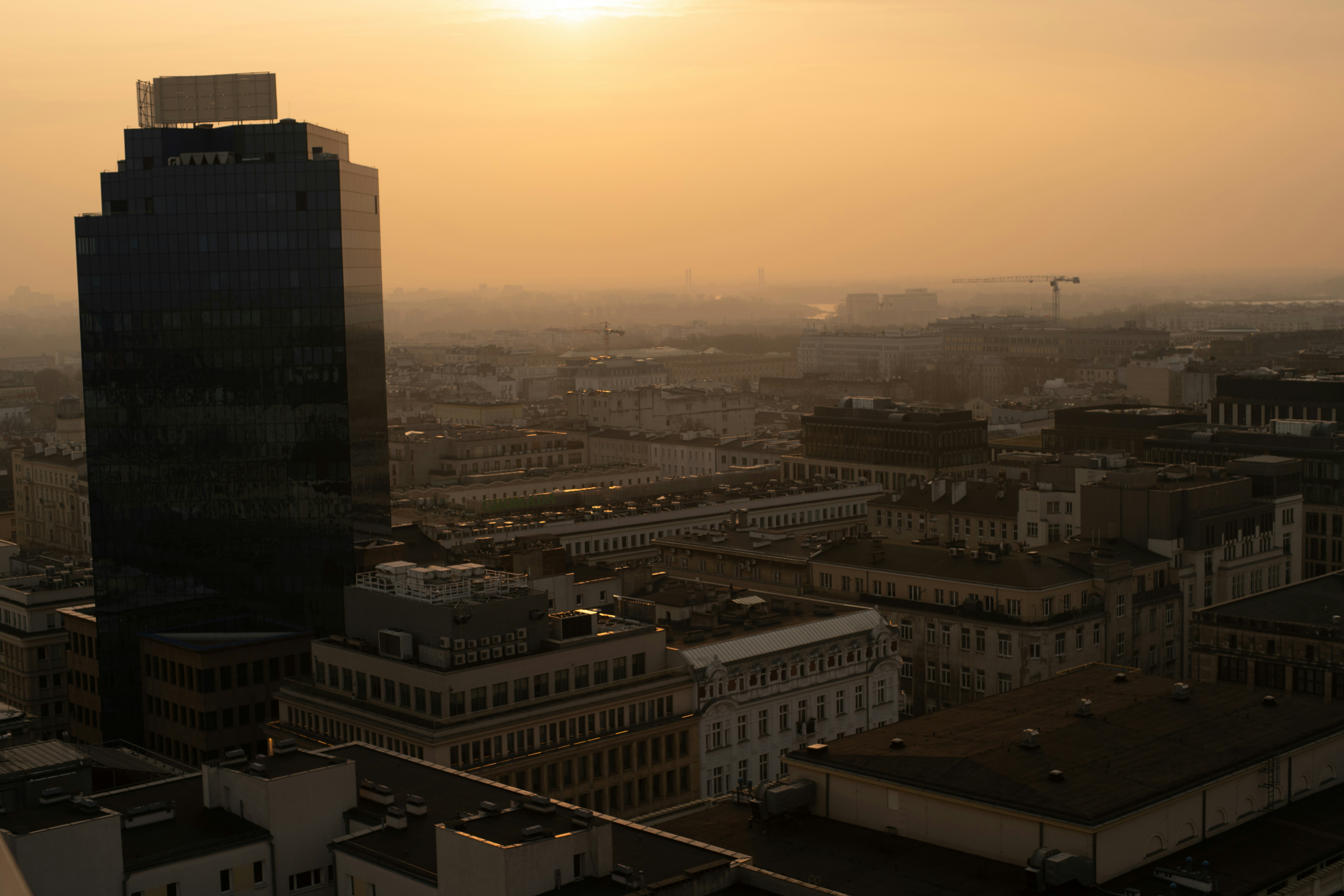City skyline at sunrise with golden hues.