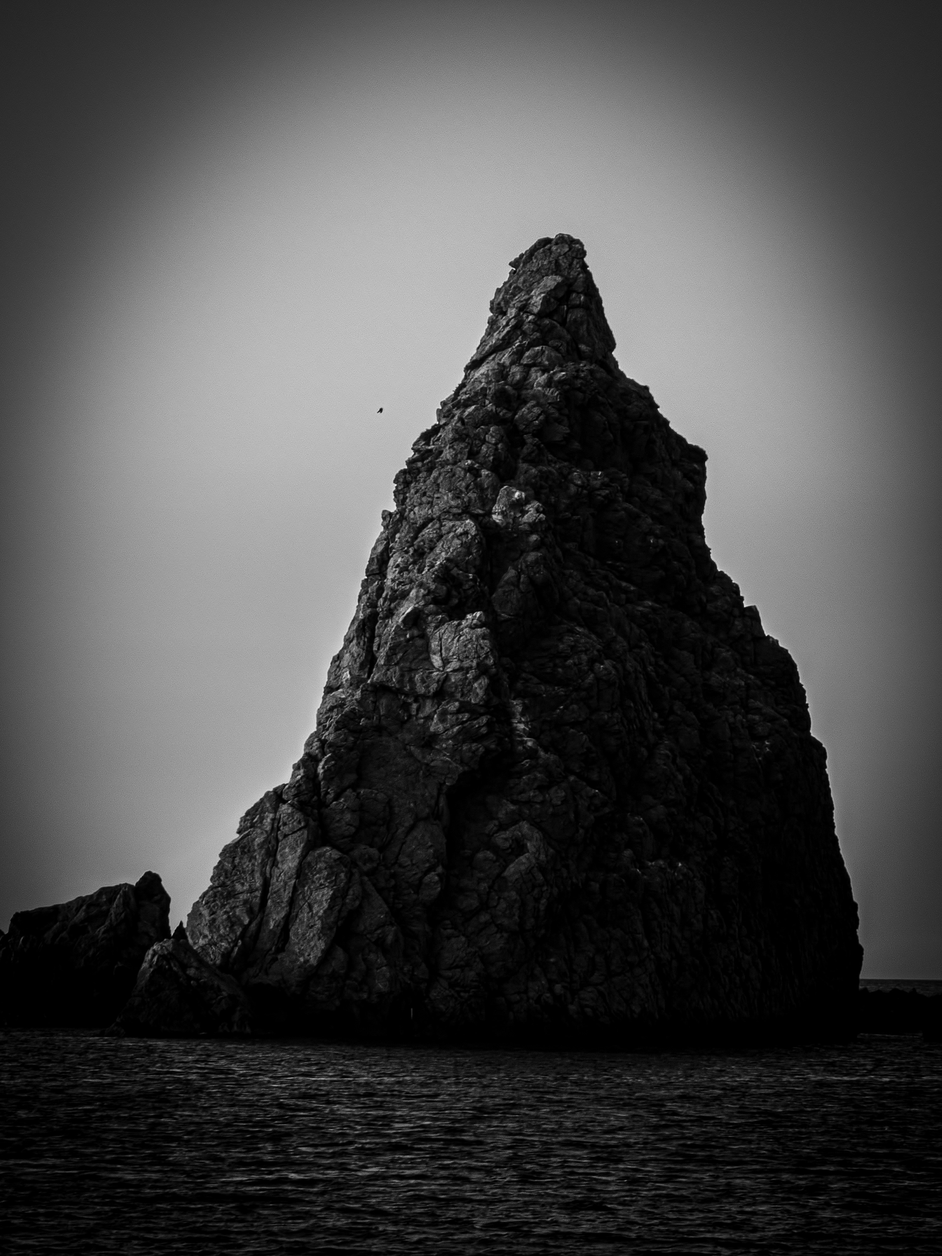 A majestic rock formation stands over the water