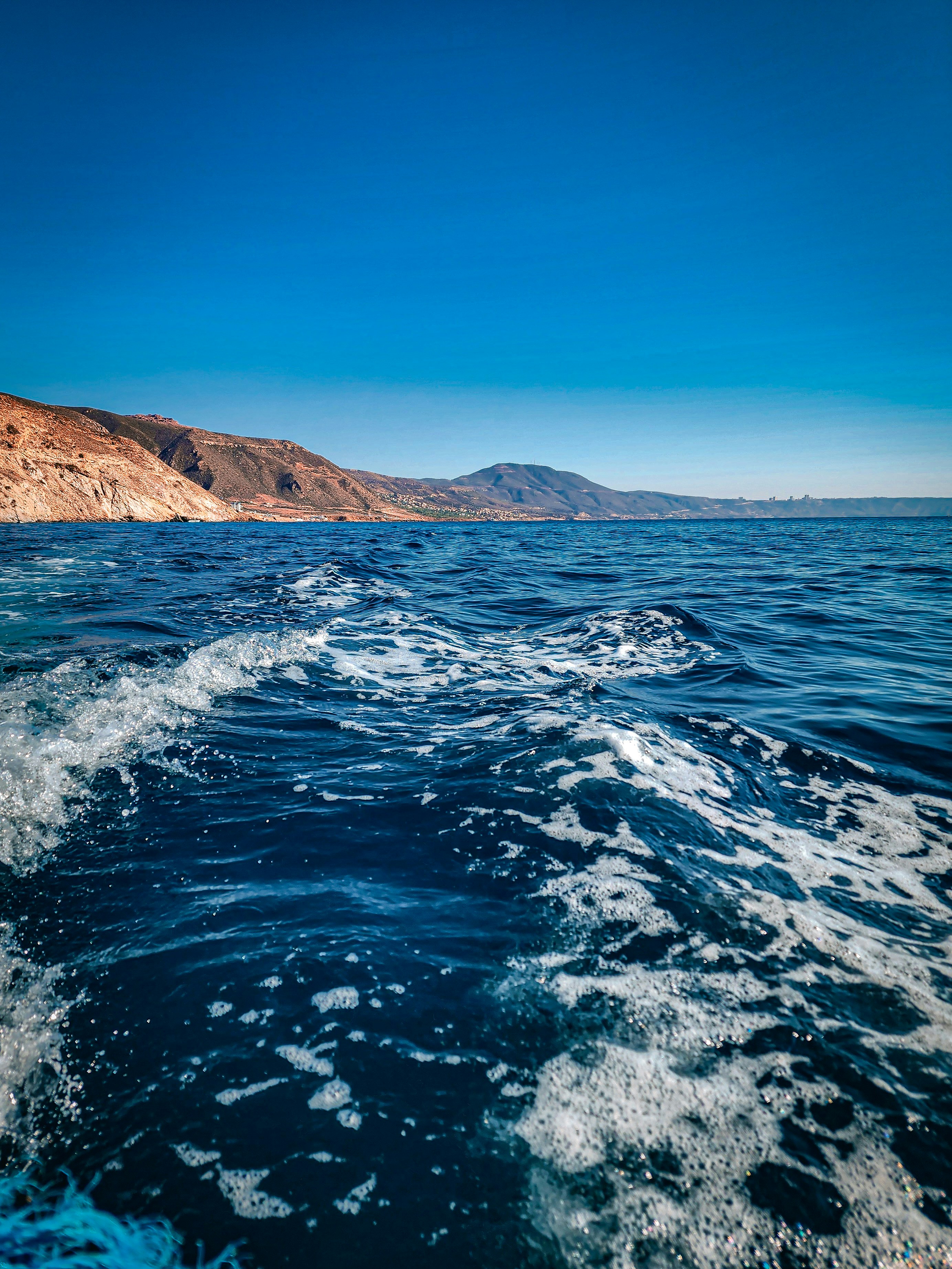 Les vagues s’écrasent alors qu’un bateau navigue sur l’océan.