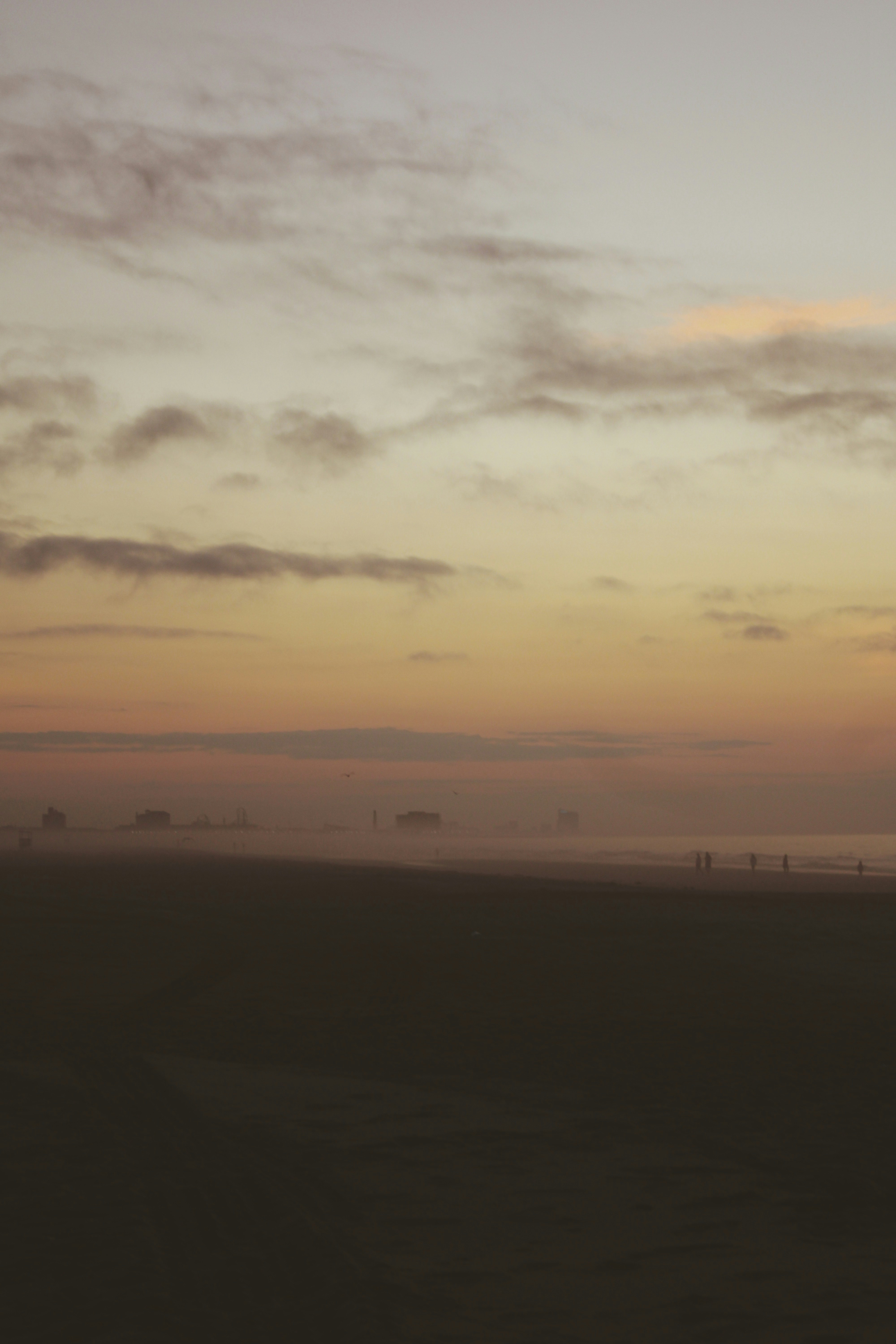 A foggy beach at sunset, serene and soft.