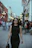 Woman strolls down a street, looking stylish.