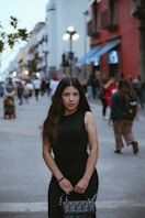 Woman poses on a busy city street.