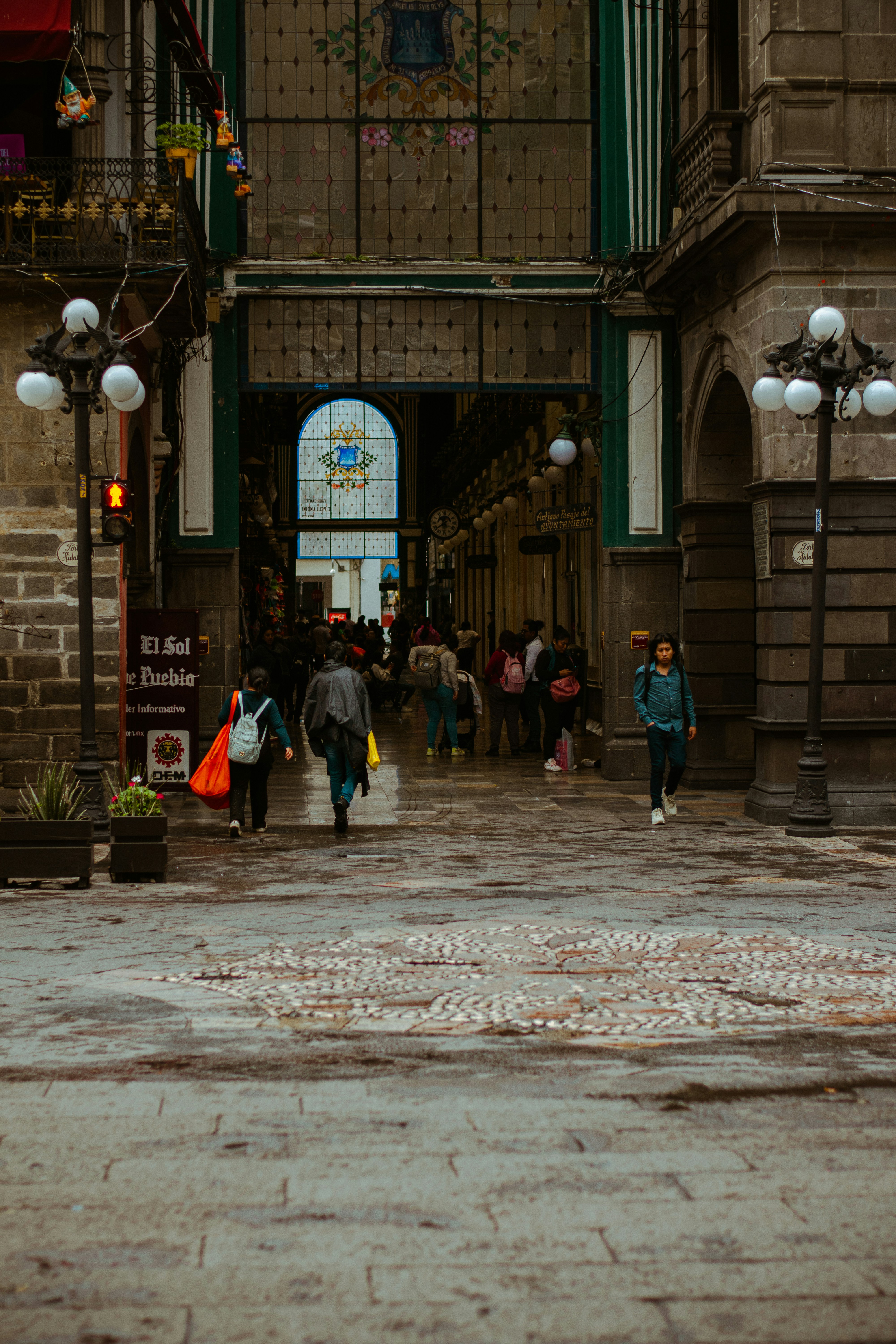 People walk under an arched building.