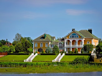 Elegant houses sit atop a grassy hill.