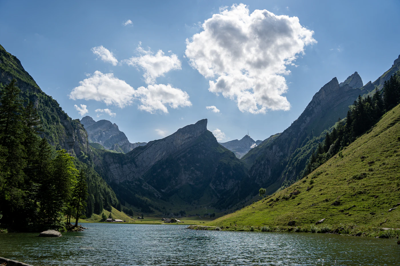 Seealpsee surrounded by green alpine slopes in Appenzell, Switzerland.