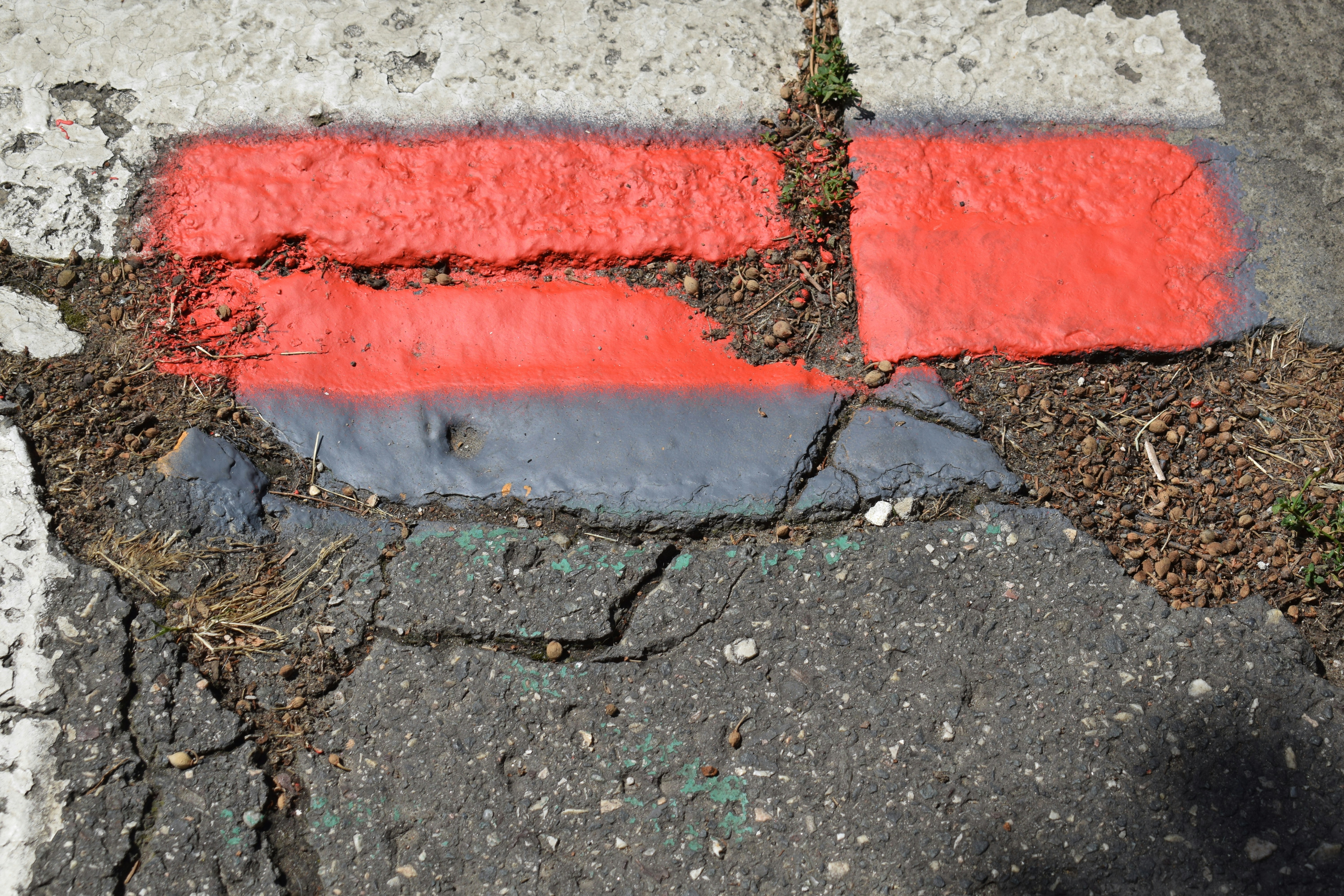 peeling and faded curb paint on weathered concrete