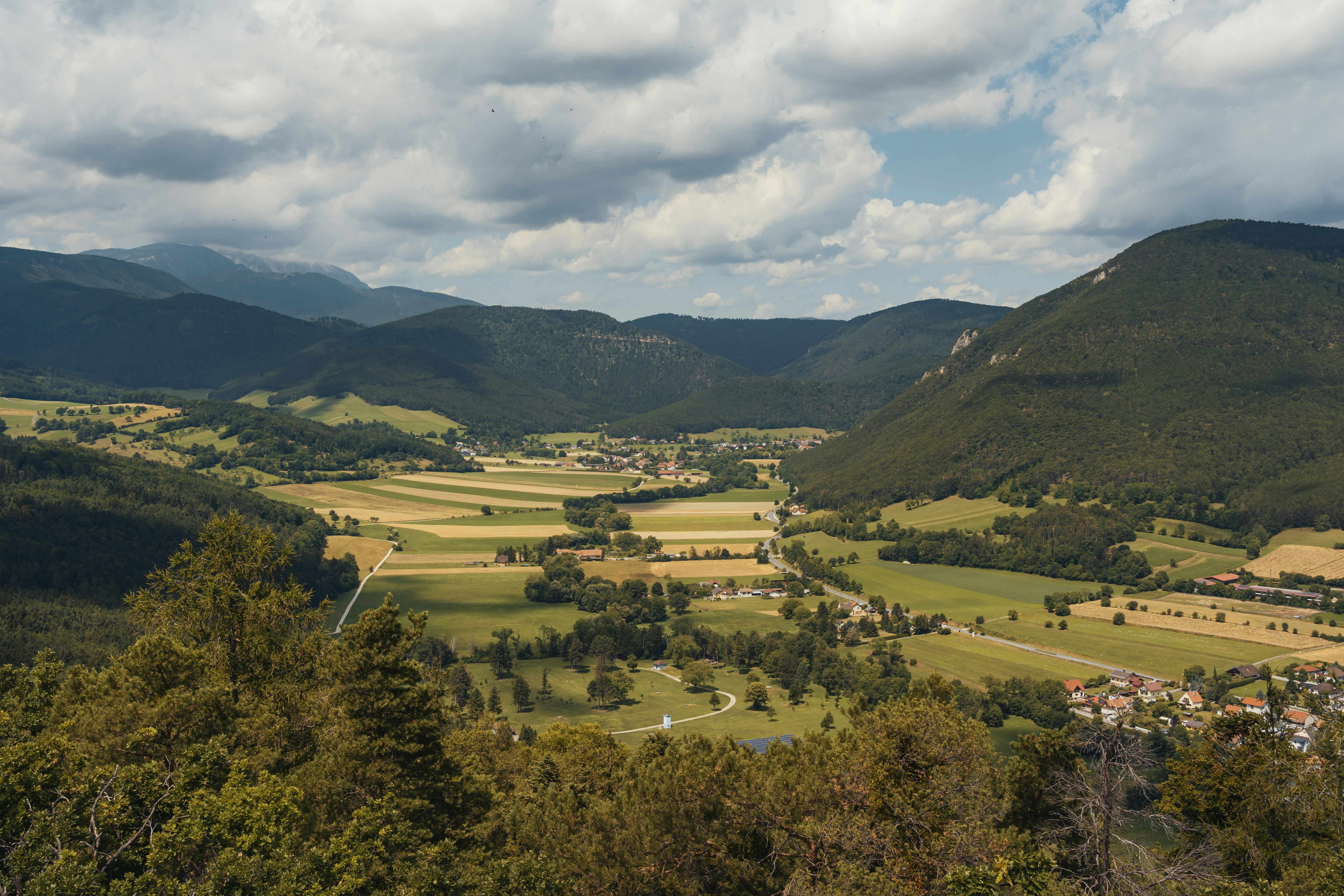 Rolling hills and a valley under a cloudy sky.