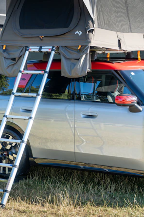 A rooftop tent is mounted on a car.