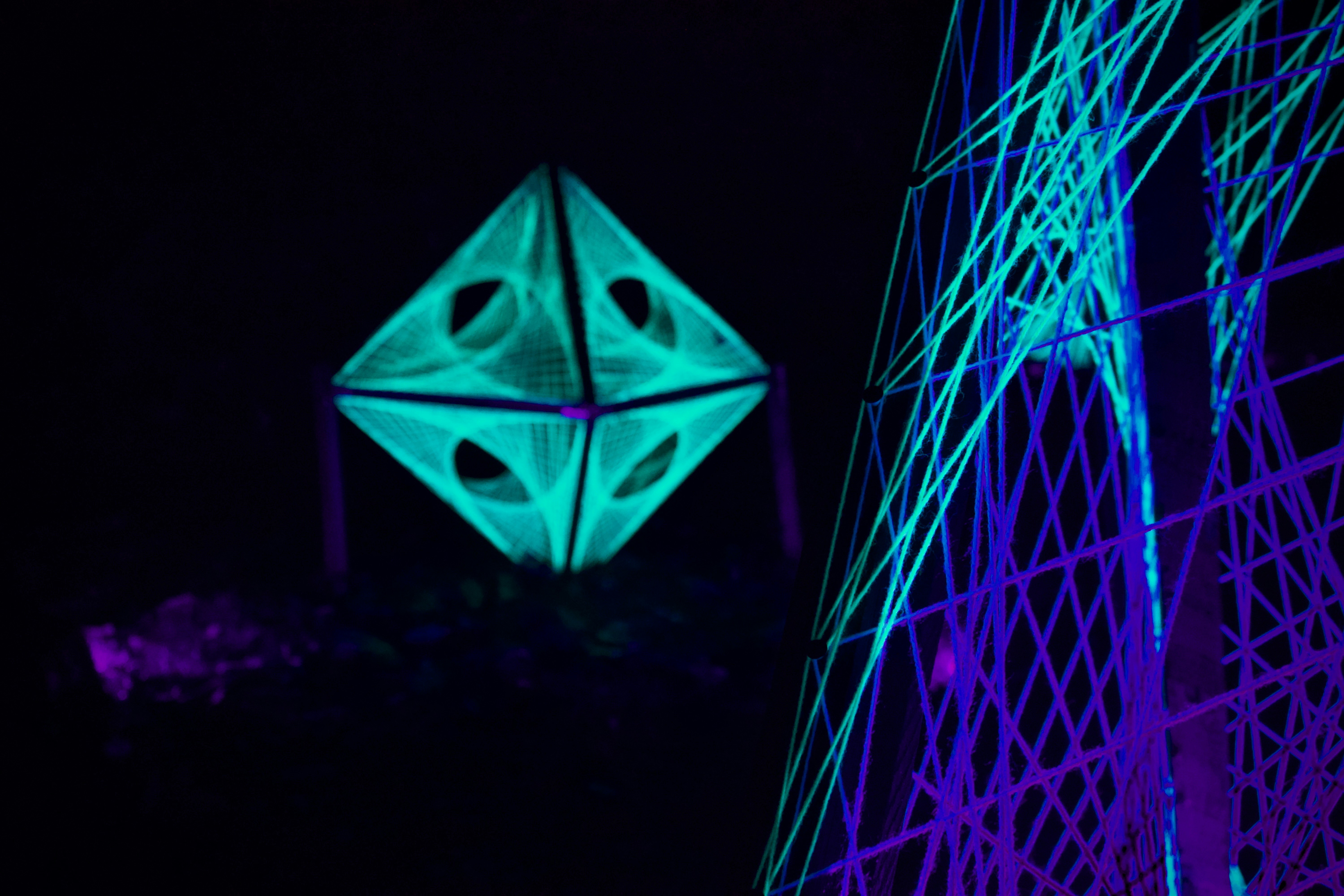 Glowing geometric shapes illuminate the night.