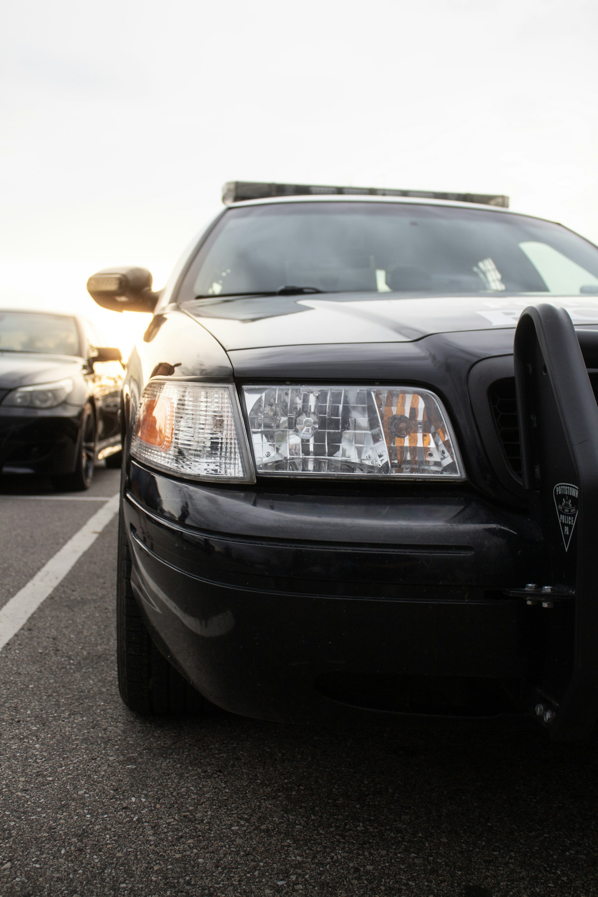 A police car parked in the evening sunlight.