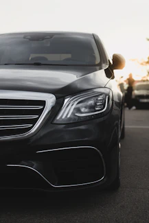 A sleek, black car gleams in the sunlight.