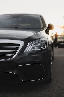 A sleek, black car gleams in the sunlight.