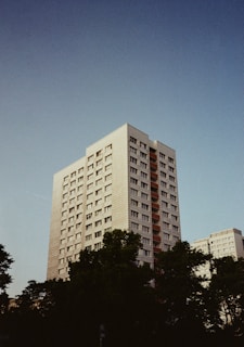 A tall apartment building stands beneath a clear sky.