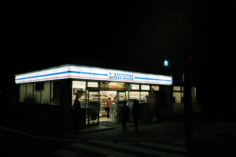 A Lawson convenience store illuminated at night on a city street