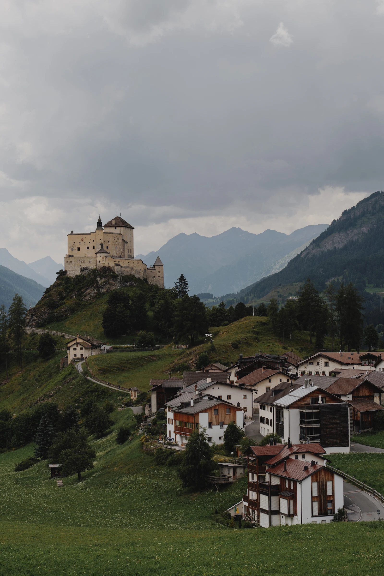 Château perché sur une colline au-dessus d'un village dans les Alpes suisses (image d'illustration)
